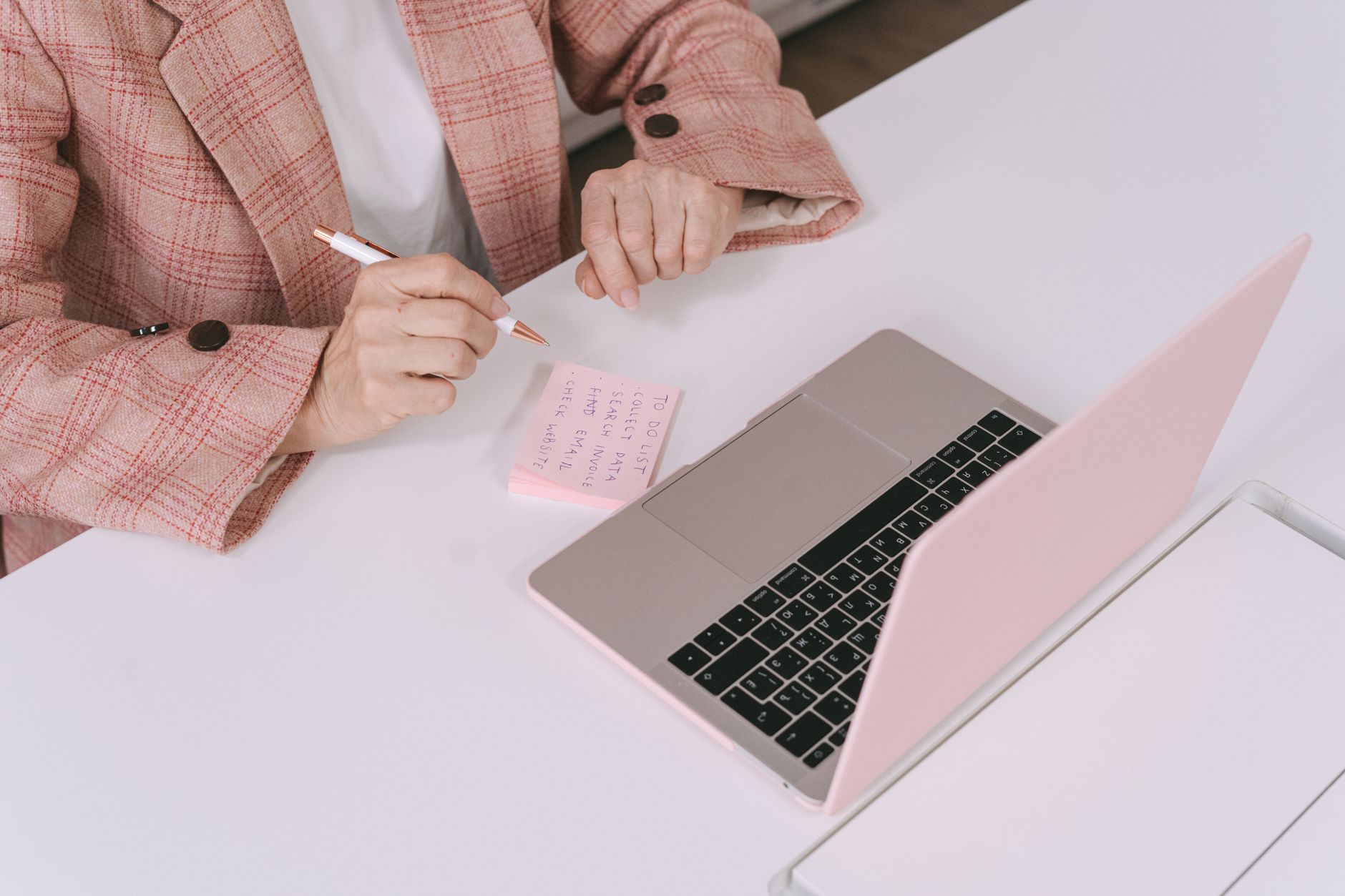Người kiểm tra lịch và ghi chú trên laptop để nộp báo cáo đúng hạn